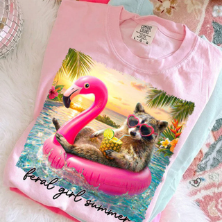 Blossom Comfort Colors graphic tee with raccoon flamingo float tropical design folded flat lay