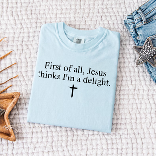 Chambray Comfort Colors tee with First of All Jesus Thinks I'm a Delight script and cross design, folded flat lay