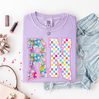 Floral checkered RN Graphic Top in violet with colorful floral R and rainbow checkered N design
