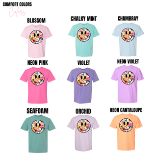 Floral smiley face top shown in nine Comfort Colors options including Blossom, Chalky Mint, Chambray, Neon Pink, Violet, Neon Violet, Seafoam, Orchid, and Neon Cantaloupe