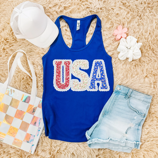 Royal blue racerback tank flat lay with floral USA letters in red white and blue with lace border detail
