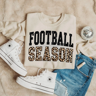 Sand Football Season crewneck sweatshirt with black and leopard print design styled with white sneakers and jeans