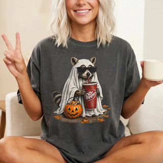 Pepper Comfort Colors ghost raccoon graphic tee with sunglasses, soda cup, and jack-o-lantern