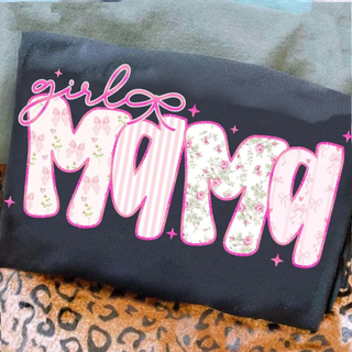 Black graphic tee folded with pink girl mama floral stripe and bow patterned letter design on leopard print background