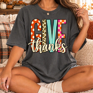 Give Thanks graphic on a charcoal short-sleeve shirt, with colorful patterned letters and layered script lettering.