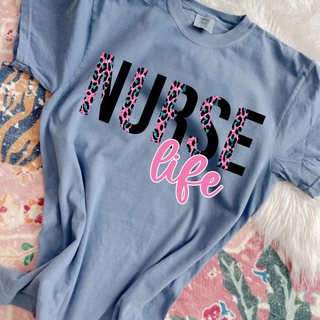 Comfort Colors blue jean tee laid flat with NURSE life pink glitter leopard design
