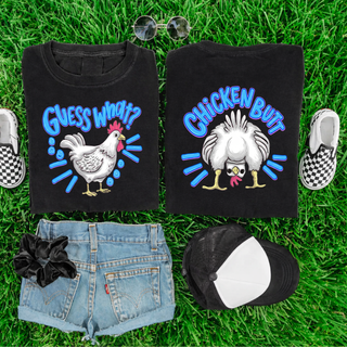 Two folded black Comfort Colors Guess What Chicken Butt Graphic Top tees showing front Guess What chicken design and back Chicken Butt graphic with blue lettering