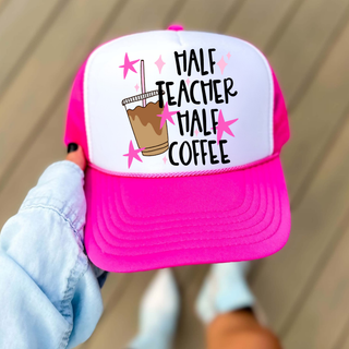 neon pink trucker hat with half teacher half coffee text and iced coffee graphic, held outdoors
