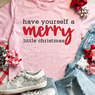 "Have yourself a merry little christmas" design in black script with "merry" in red cursive lettering on a pink tee