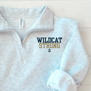 ash grey quarter zip pullover with wildcat strong lettering, flat lay on wood background