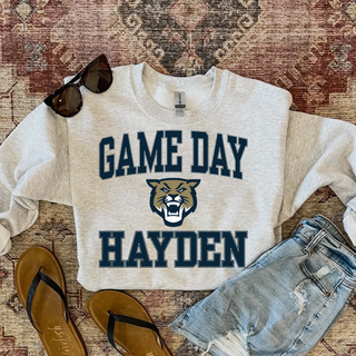 Hayden Wildcats Game Day Top featuring an arched GAME DAY wordmark over a wildcat mascot head icon and bold HAYDEN lettering in navy and gold