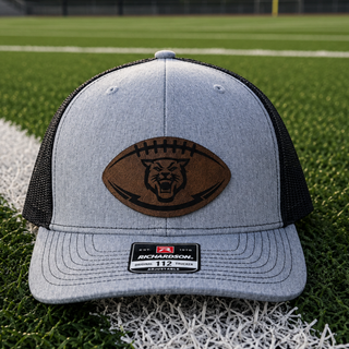 Hayden Wildcats trucker hat with football shaped leather patch engraved with wildcat mascot face on heather grey and black Richardson 112 snapback
