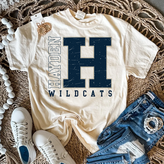 Cream T-shirt with a large distressed navy H outlined in gold, vertical Hayden lettering, and Wildcats beneath.