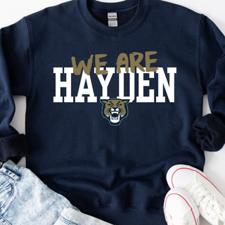 Navy crewneck sweatshirt with Hayden Wildcats We Are Hayden design featuring gold we are text above bold block Hayden text with wildcat mascot face below
