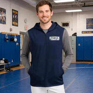 Smiling man in a wrestling room wearing a true navy sleeveless hooded quarter-zip with Hayden in white distressed block letters on the left chest
