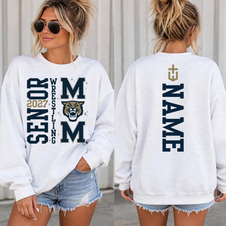 Woman wearing a white crewneck sweatshirt shown from the front and back; the front has vertical Senior 2027 Wrestling lettering beside a navy M, gold and navy wildcat head, and second M, and the back has a gold cross emblem above a vertical navy name