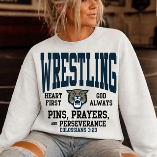Hayden Wildcats wrestling top on a model in white with a navy arched WRESTLING design, wildcat head logo, Heart First, God Always, and Pins, Prayers, and Perseverance