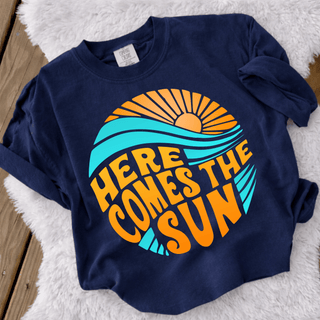 Here Comes the Sun Graphic Top in true navy with retro orange sun teal waves and bold Here Comes the Sun lettering
