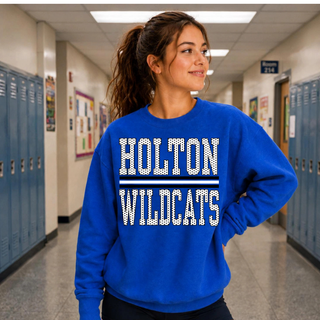 Woman wearing a royal blue crewneck with stacked black and white polka dot-texture HOLTON WILDCATS lettering divided by a striped bar