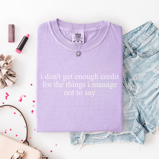 Violet tee folded flat showing i don't get enough credit for the things i manage not to say in small white centered text
