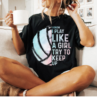 Model wearing black tee with I KNOW I PLAY LIKE A GIRL TRY TO KEEP UP pastel volleyball graphic front view
