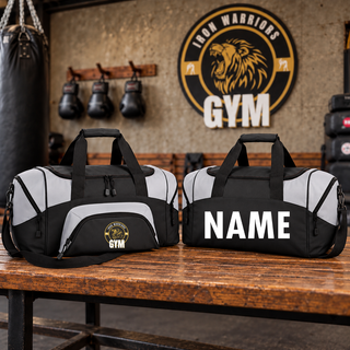 Two black and light grey duffel bags on a bench in a gym, one with the Iron Warriors Gym lion crest on the front pocket and one with a name in white lettering