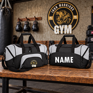 Two black and light grey duffel bags on a bench in a gym, one with the Iron Warriors Gym lion crest on the front pocket and one with a name in white lettering