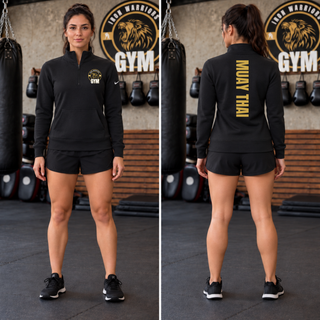Woman in a black fleece half-zip with the Iron Warriors Gym lion crest on the left chest, front and back views showing Muay Thai in gold vertical lettering