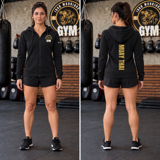 Woman wearing a black full-zip hoodie with the Iron Warriors Gym gold lion crest on the left chest, shown from the front and the back with Muay Thai in gold vertical lettering down the back