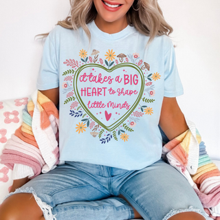 Woman wearing chambray Comfort Colors tee with it takes a BIG HEART to shape little minds floral heart design

