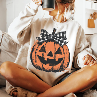 heather dust adult top with distressed jack o lantern and buffalo plaid bow graphic, model holding coffee mug
