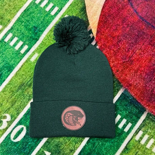 Forest Green Jackson Heights Cobras pom beanie with a round laser engraved leather Cobra mascot patch