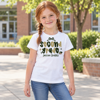 Girl wearing Jackson Heights Cobras Second Grade Bow Top in white featuring second grade bubble lettering with a bow accent, sparkles, Jackson Heights script, and a cobra head icon