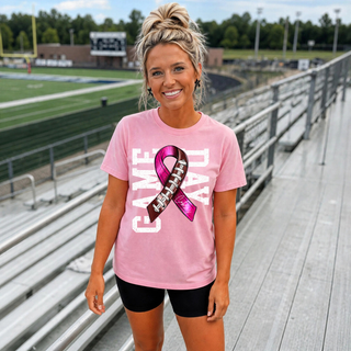 Woman wearing a bright pink Jackson Heights Jr. Cobras Game Day football ribbon performance top in stadium bleachers