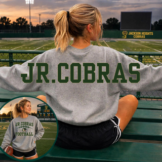 Woman wearing an oversized Sport Grey Jackson Heights Jr. Cobras Victory Arch crewneck showing front artwork and back shoulder lettering