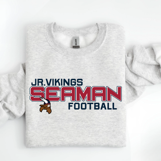 ash grey Gildan crewneck with jr. vikings seaman football blitz design and viking logo, folded on white surface
