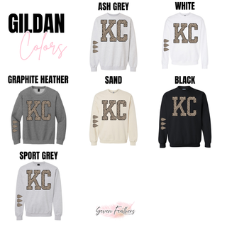 Gildan crewneck sweatshirts in ash grey, white, graphite heather, sand, black, and sport grey with KC lettering in leopard print and leopard print arrowheads on the sleeve