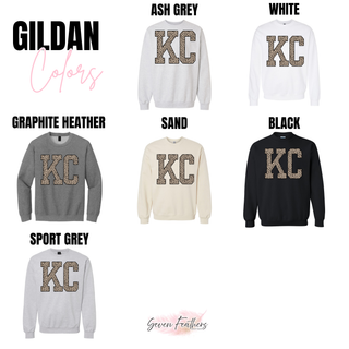 Gildan crewneck sweatshirts in ash grey, white, graphite heather, sand, black, and sport grey with KC lettering in leopard print and black outline