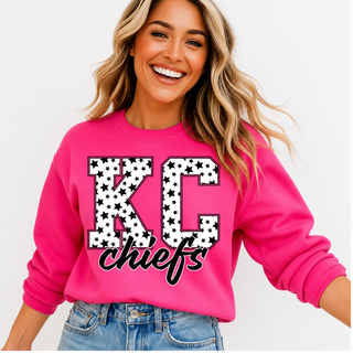 Woman wearing pink crewneck with KC star pattern lettering and script city pride graphic