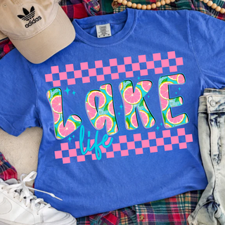 Flo blue Comfort Colors tee flat lay with lake life checkered citrus graphic, hat and jeans
