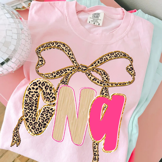 Leopard Bow CNA Graphic Top in blossom with leopard print bow and pink CNA lettering design

