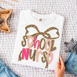 Leopard Bow School Nurse Graphic Top in white with leopard print bow and pink School Nurse lettering design
