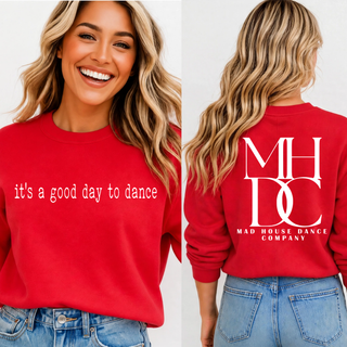 Woman wearing red crewneck with it's a good day to dance on the front and MHDC Mad House Dance Company monogram on the back