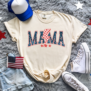 Mama patriotic lightning bolt stars graphic on ivory top styled with denim shorts, white sneakers, blue trucker hat, and American flag accessory