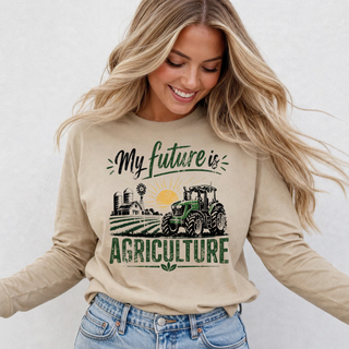 Woman wearing tan My Future is Agriculture long sleeve top with tractor and farm graphic design