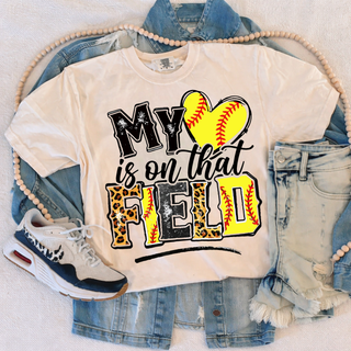 Ivory Comfort Colors top with softball heart graphic and leopard field text on denim flatlay