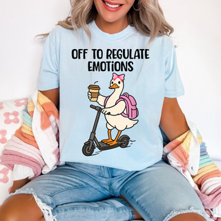 Chambray Comfort Colors tee with off to regulate emotions duck graphic featuring a cute duck riding a scooter with a coffee cup, pink bow, and backpack