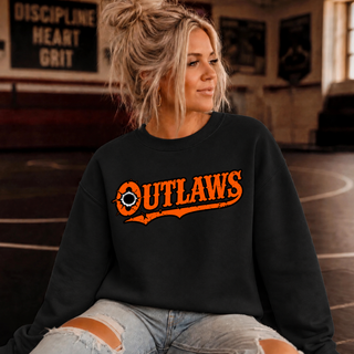 Woman in a wrestling room wearing a black crewneck sweatshirt with orange western-style Ogden's Outlaws Wrestling bullet hole lettering, a swash tail and a bullet hole in the O