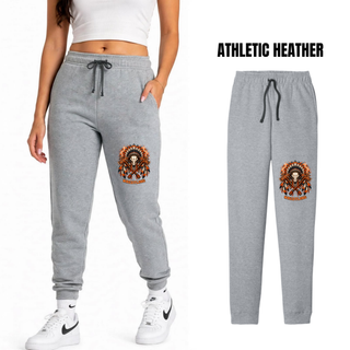 Woman wearing athletic heather grey core fleece joggers with the Ogden's Outlaws Wrestling feathered skull and crossed axes graphic, next to a flat lay