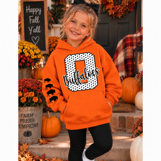 Girl in an orange hoodie with a white polka dot letter O outlined in black, black Buffaloes script, and four black buffaloes down the sleeve, standing on a fall porch with pumpkins